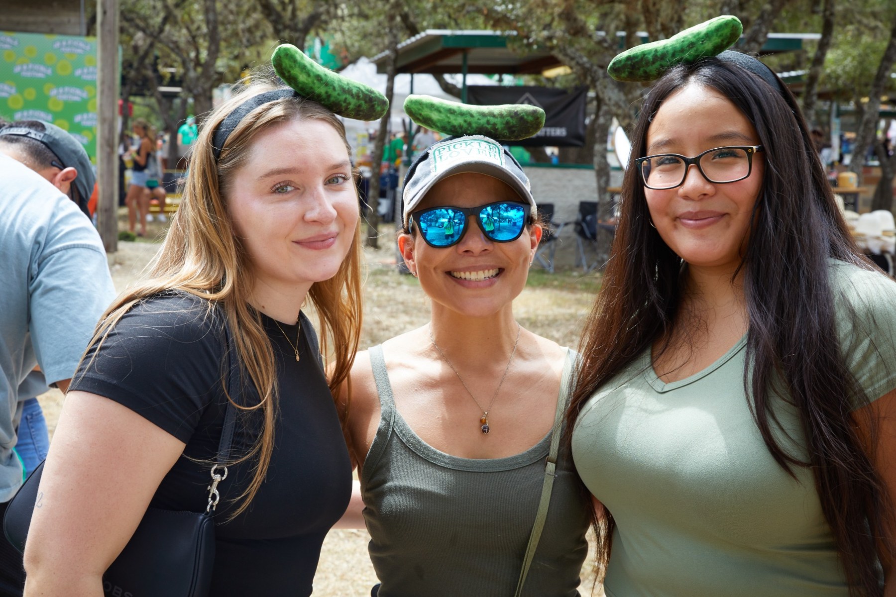 Three friends smiling together at In A Pickle Festival